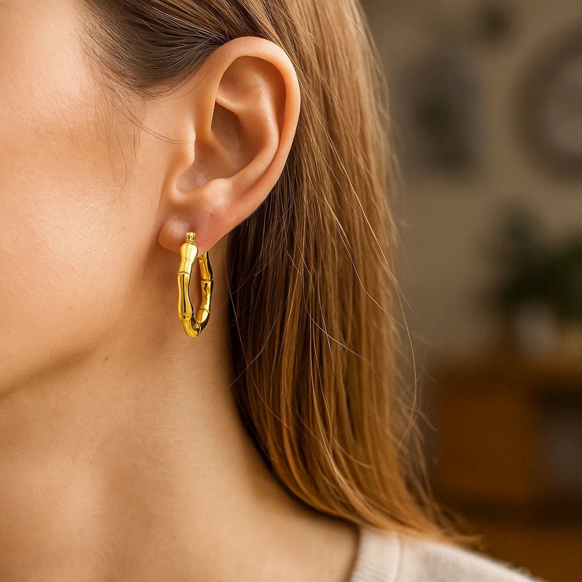 14K yellow gold bamboo hoop on the ear, side view