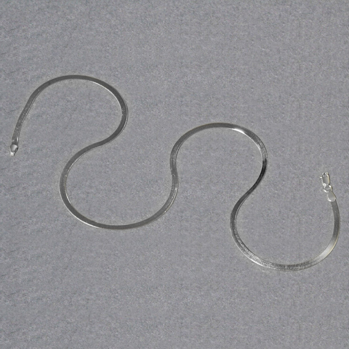 Herringbone chain in 14K white gold laid out in loops
