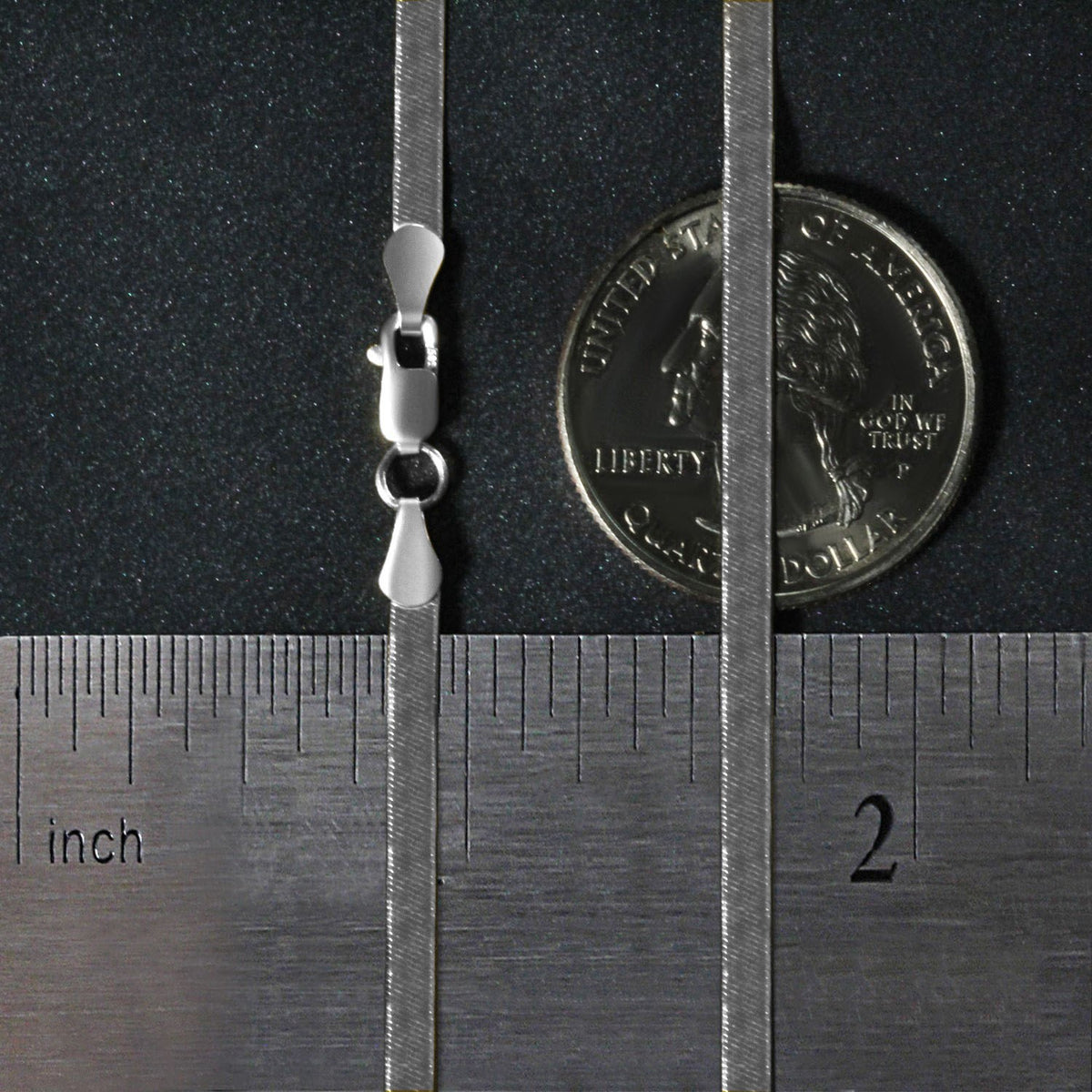 2.80mm herringbone chain in 14K white gold beside an inch ruler and a coin for scale