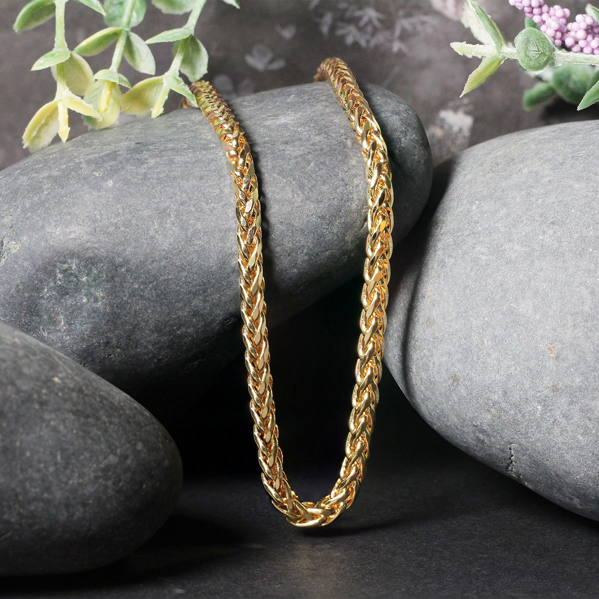 Franco chain in 14K yellow gold draped over two stones