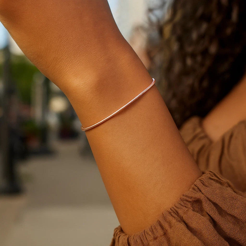1.8mm diamond-cut stack bangle in 14K rose gold worn on the arm
