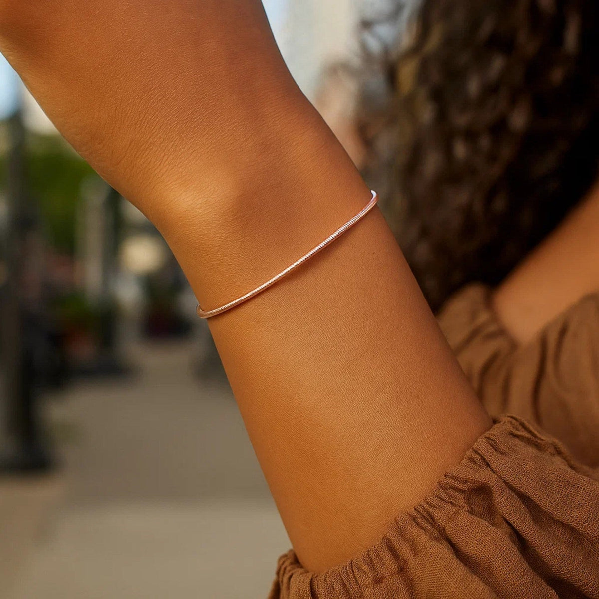 1.8mm diamond-cut stack bangle in 14K rose gold worn on the arm